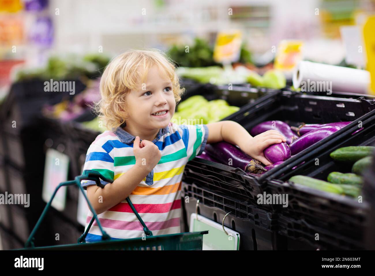 Child in supermarket buying fruit and juice. Kid grocery shopping
