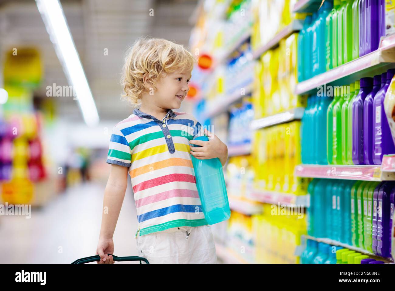 Child in supermarket buying fruit and juice. Kid grocery shopping