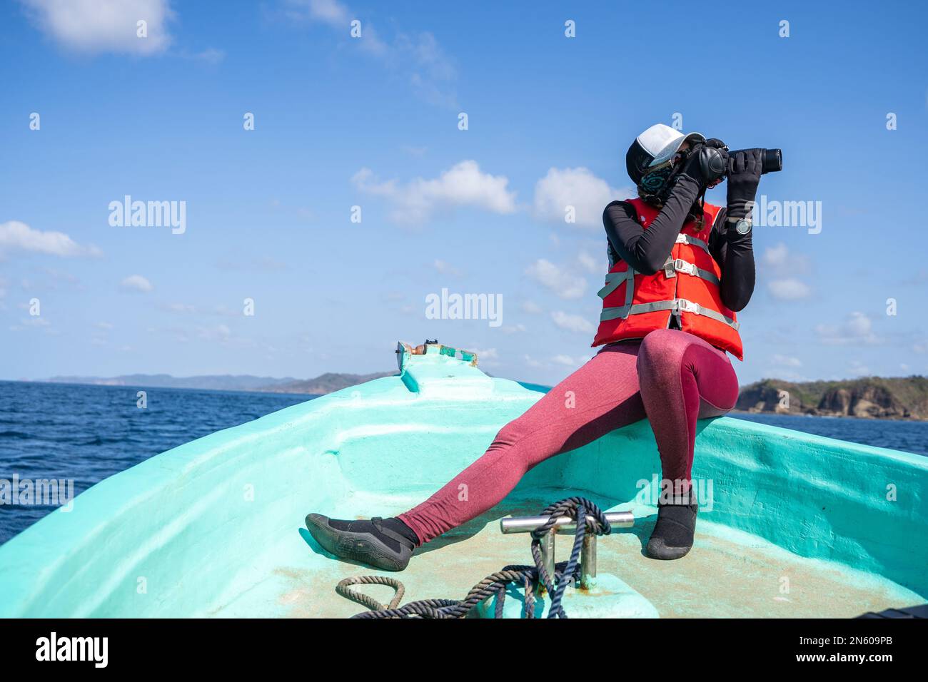 Female marine biologist taking photos while working on a boat in the