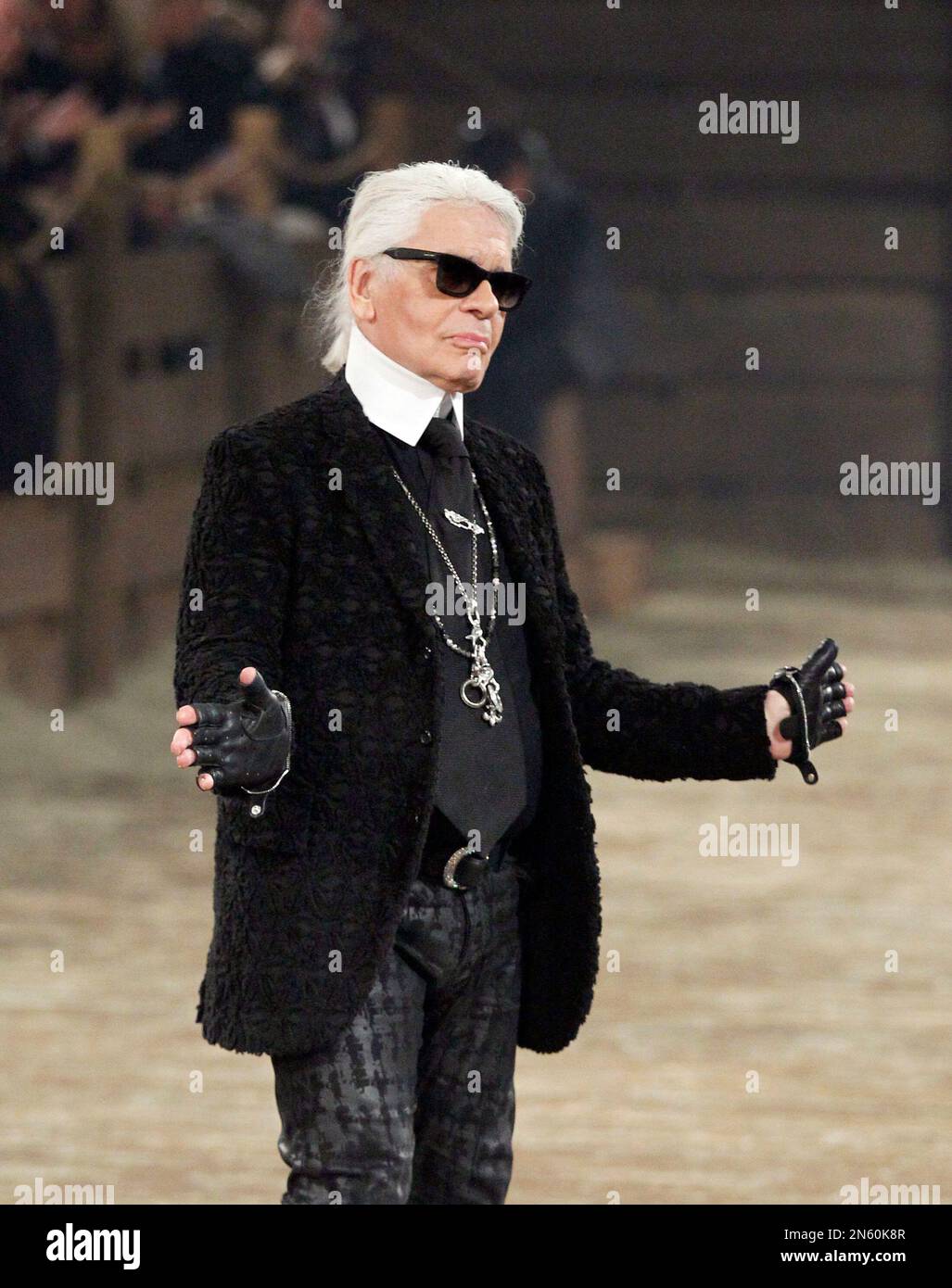 Chanel designer Karl Lagerfeld takes a bow at the end of his Metiers d'Art  fashion show, Tuesday, Dec. 10, 2013, in Dallas. For more than a decade,  designer Lagerfeld has picked a