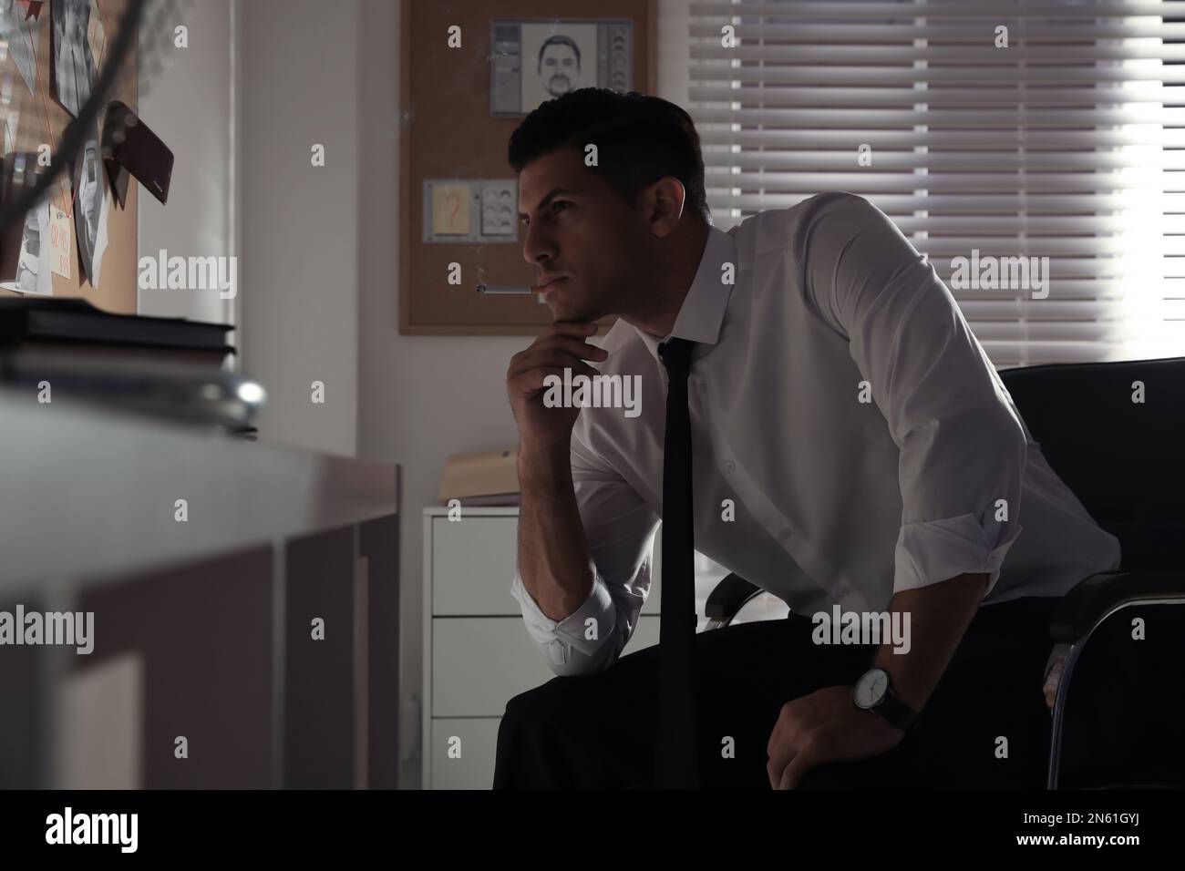 Professional detective smoking cigarette in his office Stock Photo