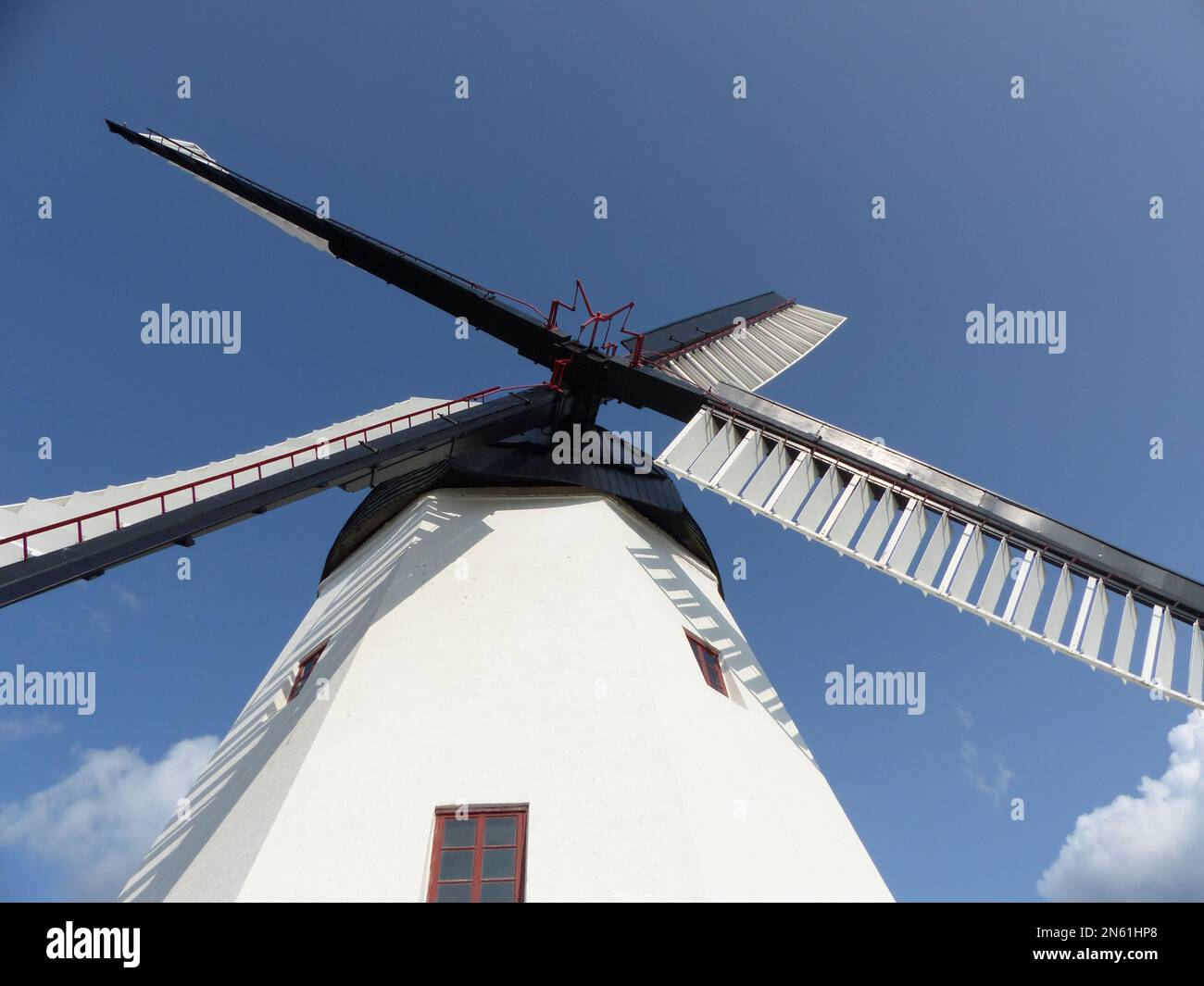 A low angle of a tall windmill with a blue sky background on Bornholm island Stock Photo