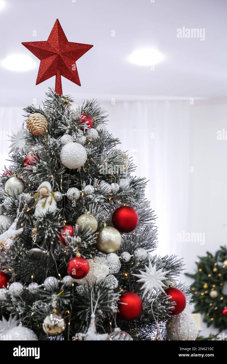 Beautiful Christmas tree with star topper in decorated room Stock Photo ...