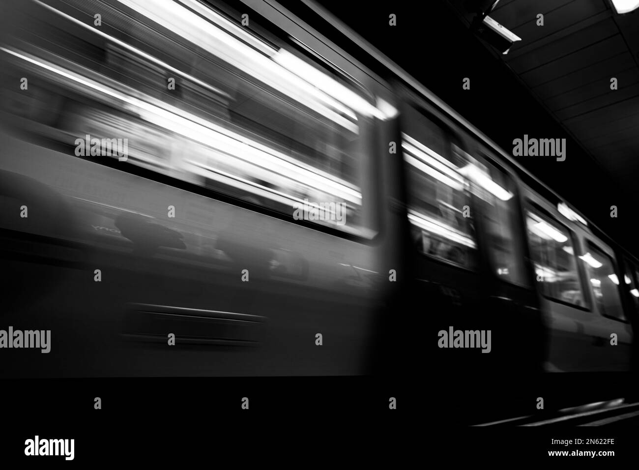 Motion blurred subway train speeding through London tube station tunnel. Stock Photo
