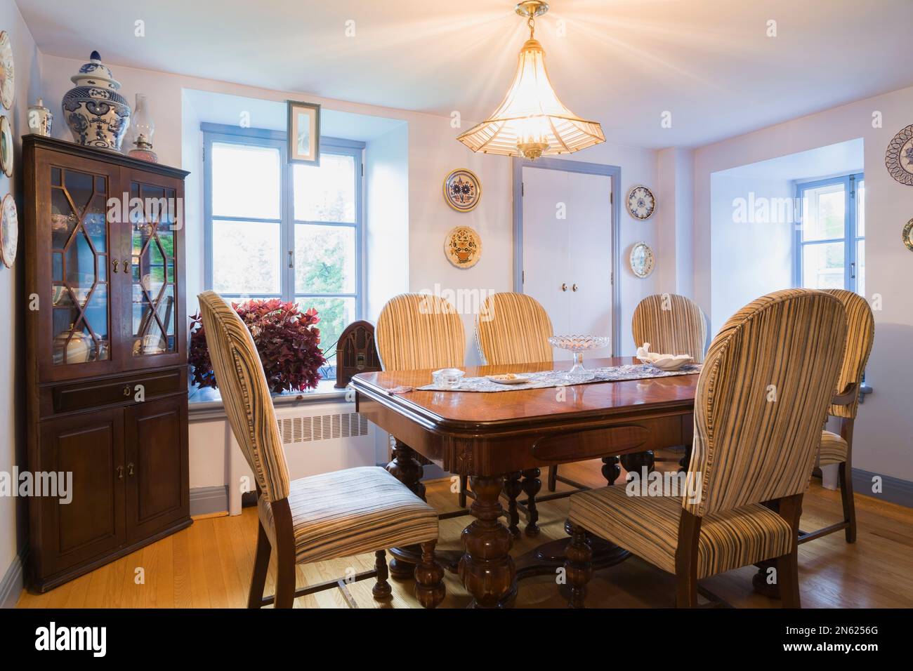 Antique walnut dining table with upholstered high back chairs in dining
