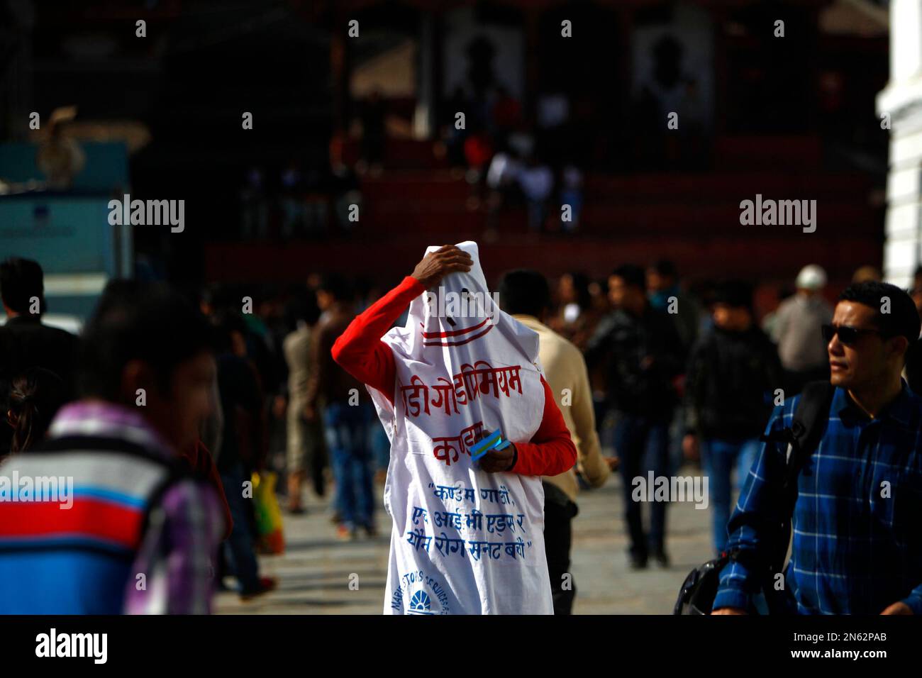 A Nepalese man dressed to resemble a condom distributes pamphlets to ...