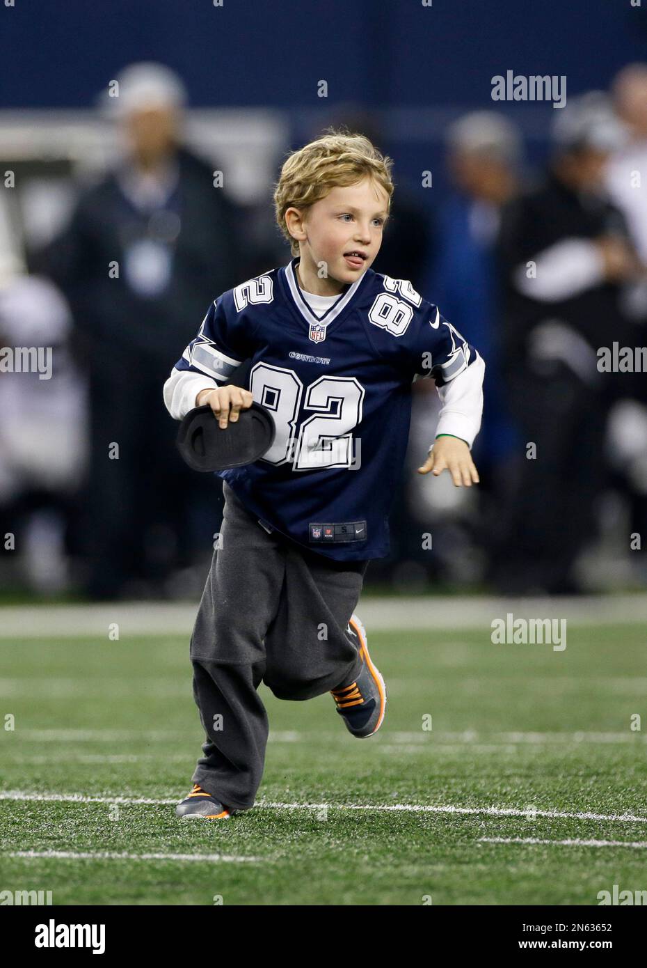 C.J. Witten, 7, the sone of Dallas Cowboys tight end Jason Witten (82) runs  the kicking tee off the field during the second half of an NFL football  game, Thursday, Nov. 28