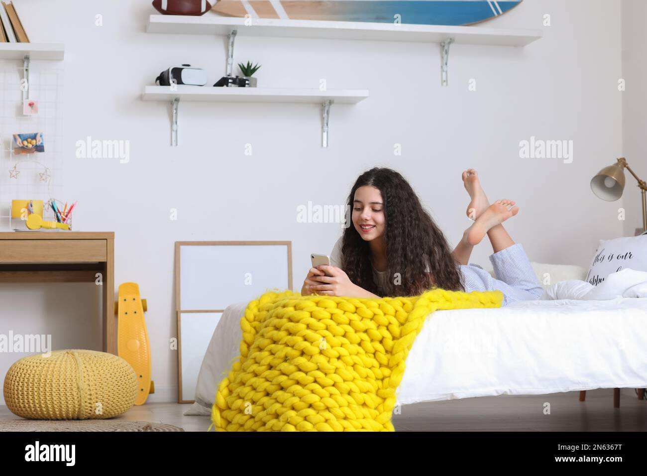 Teenage girl using mobile phone in bedroom Stock Photo - Alamy