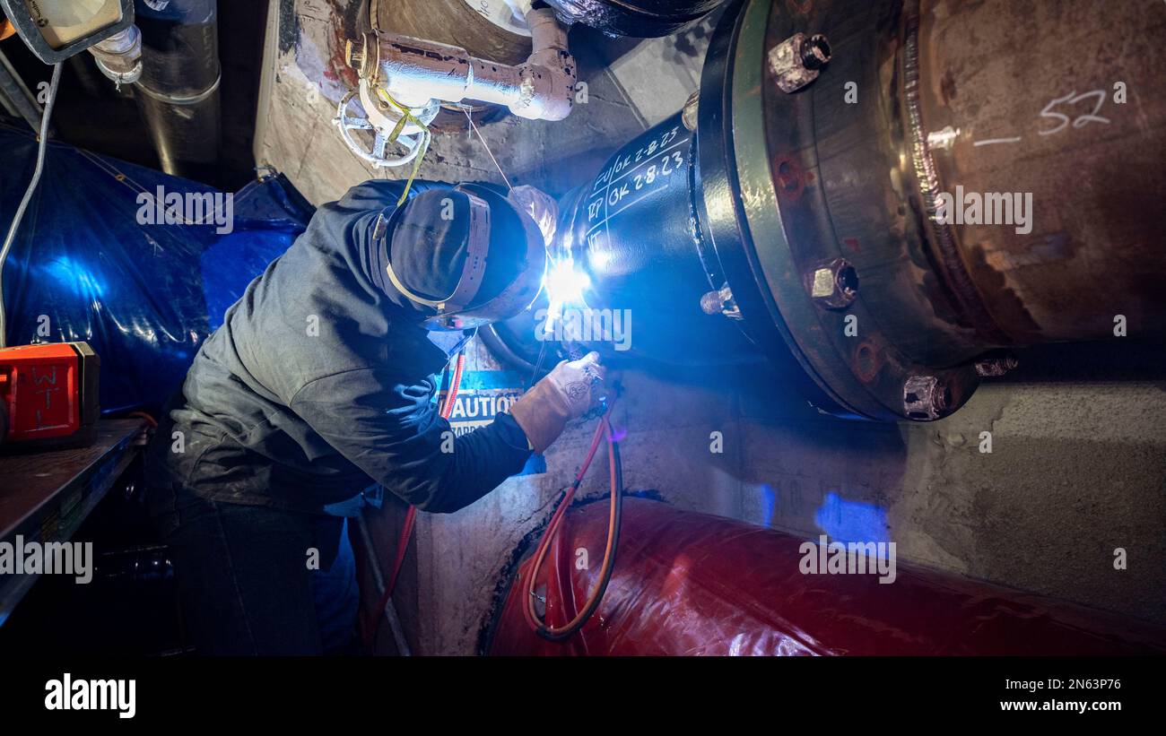 A welder performs repairs to a pipe in the Red Hill Bulk Fuel Storage Facility (RHBFSF) in Halawa, Hawaii, Feb. 8, 2023. Joint Task Force-Red Hill is currently in phase three of its five-phase defueling plan, where contractors and employees will be completing repairs and upgrades which will ensure a safe and expeditious defueling of the RHBFSF. (U.S. Army photo by Spc. Matthew Mackintosh) Stock Photo