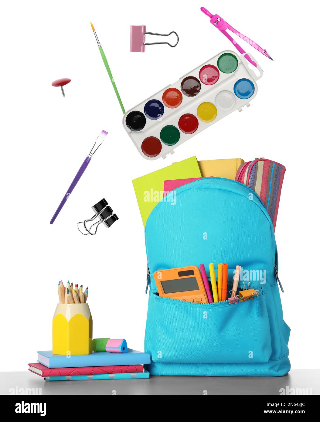 School stationery flying over backpack on white background Stock Photo