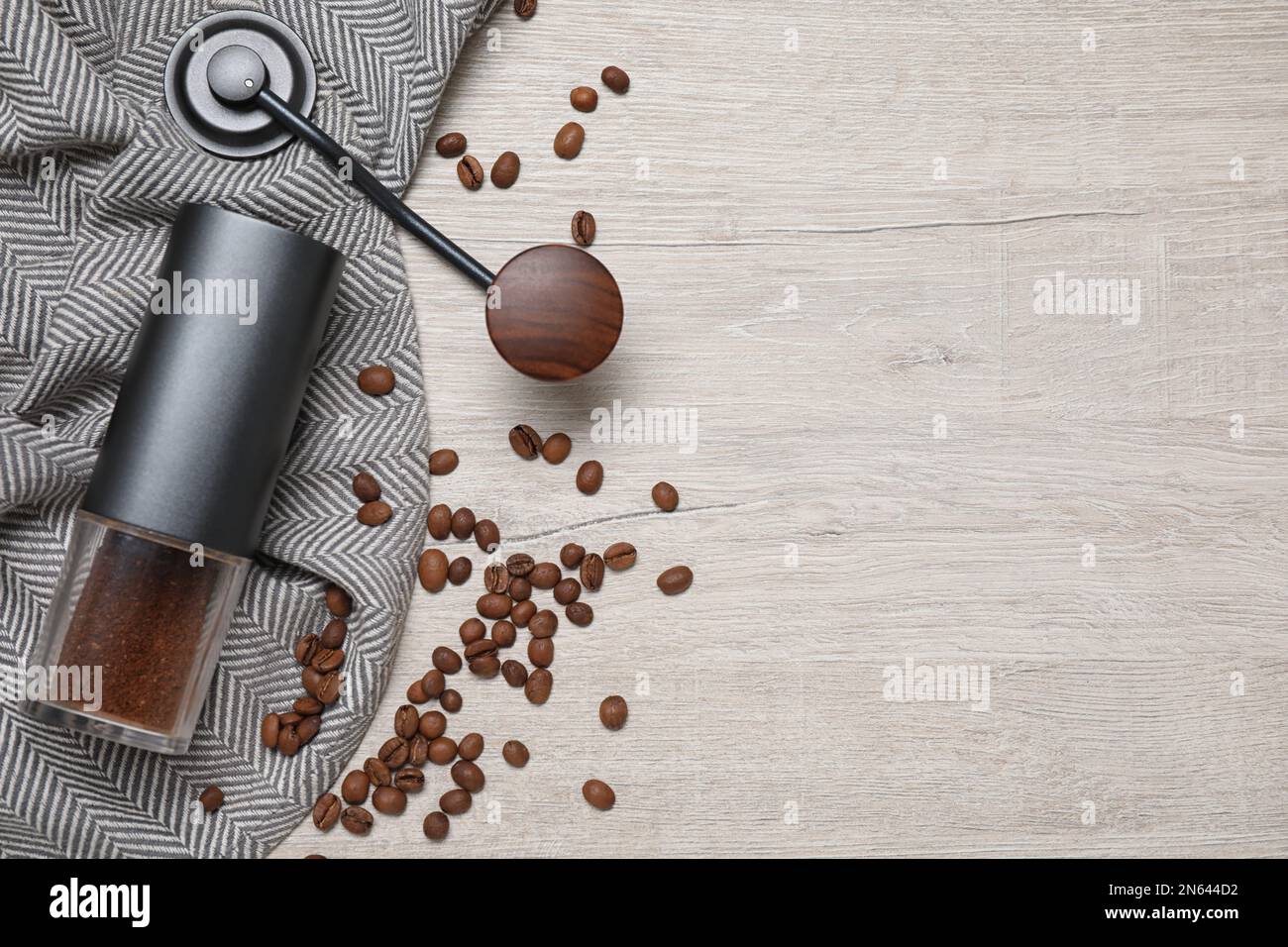 https://c8.alamy.com/comp/2N644D2/flat-lay-composition-with-coffee-grinder-and-beans-on-white-wooden-table-space-for-text-2N644D2.jpg