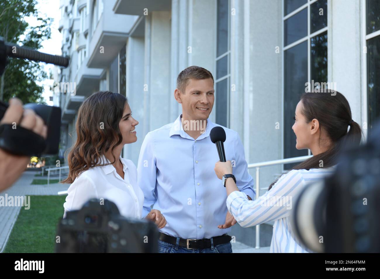 Professional journalist and operator with video camera taking interview ...