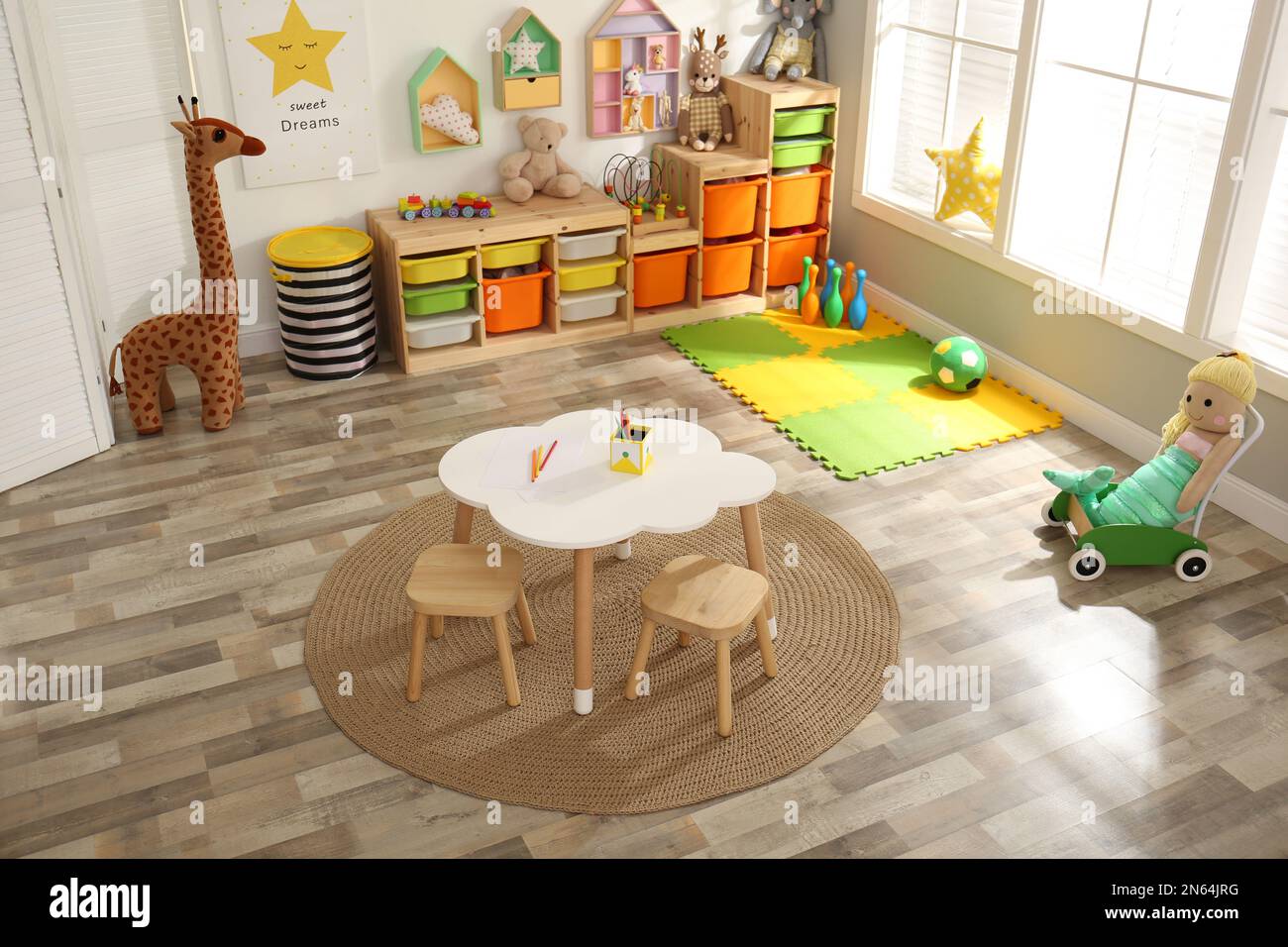 Stylish playroom interior with modern furniture and soft toys, above view Stock Photo