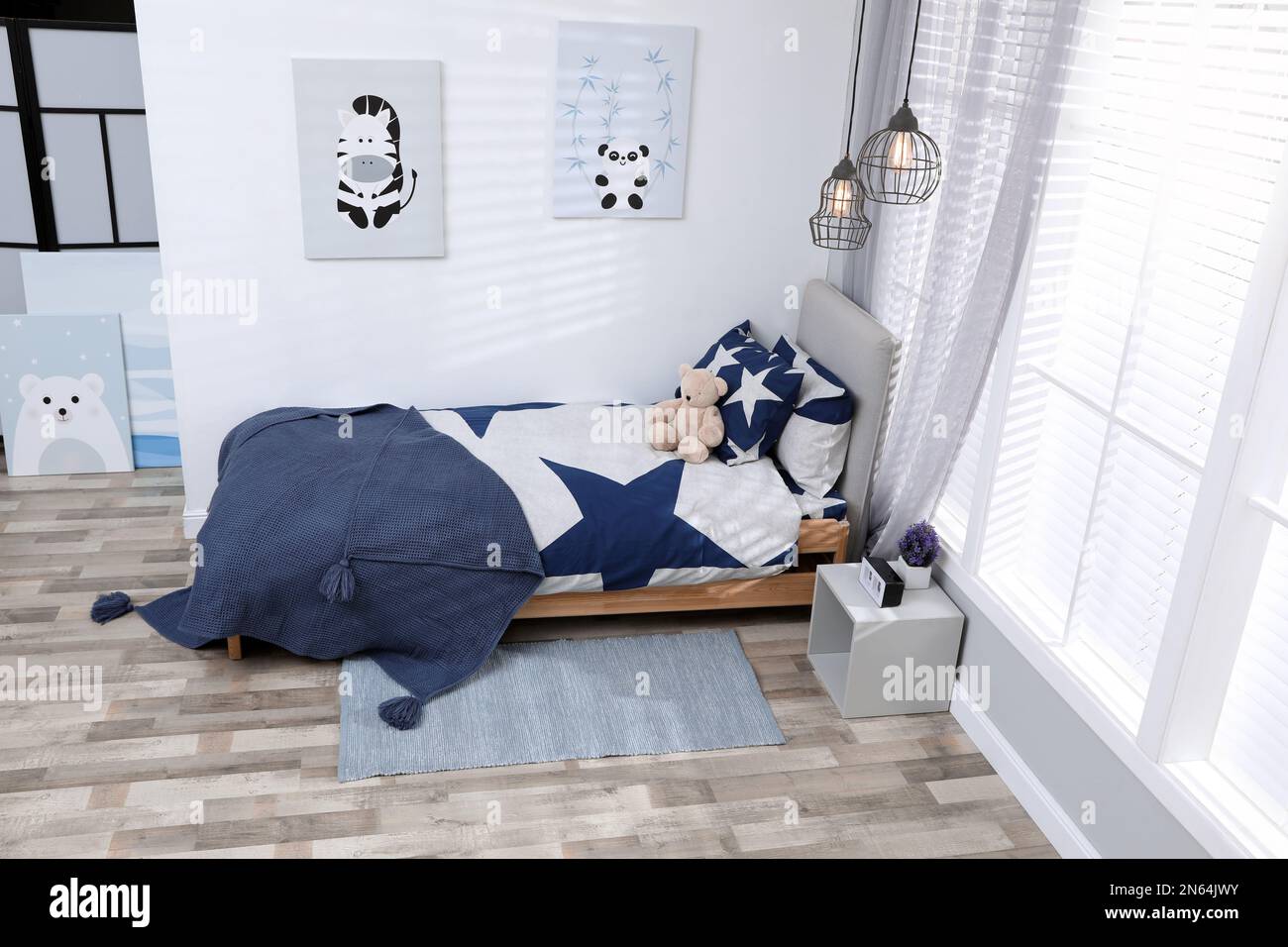 Bed with stylish linens in children's room. Interior design Stock Photo