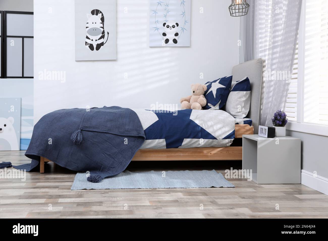 Bed with stylish linens in children's room. Interior design Stock Photo