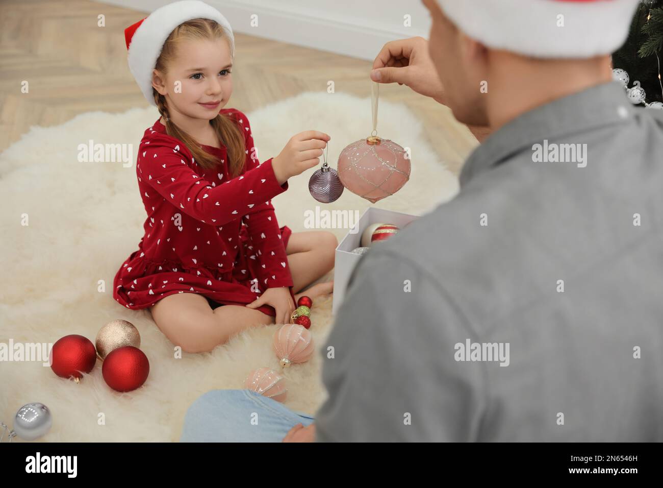 Father with his cute daughter decorating Christmas tree together ...