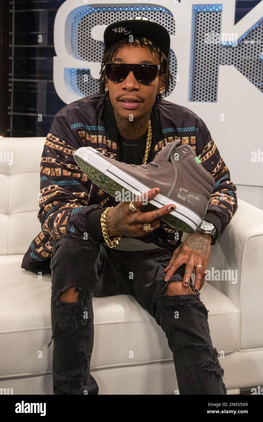 Recording artist Wiz Khalifa poses with one of his new Converse Chuck  Taylor All Star Wiz Khalifa Collection shoes during filming of SKEE Live on  Tuesday November 19, 2013 in Los Angeles,
