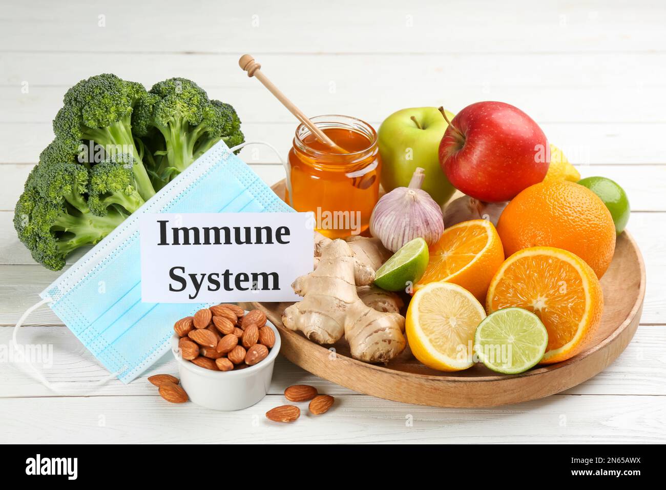 Card with phrase Immune System, medical mask and fresh products on white wooden table Stock Photo
