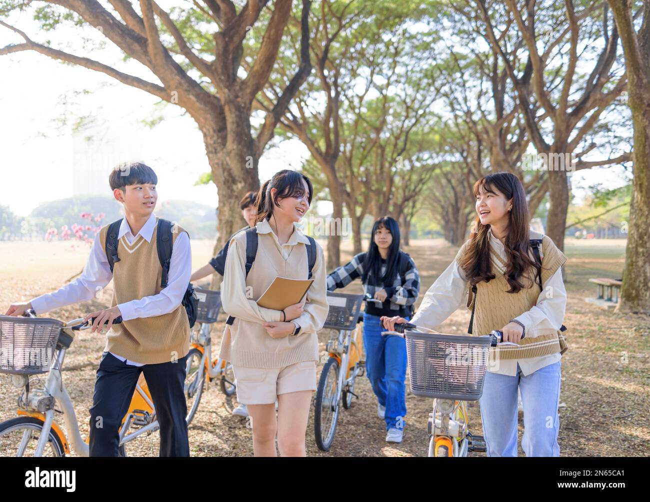 Happy students walking together in the park Stock Photo
