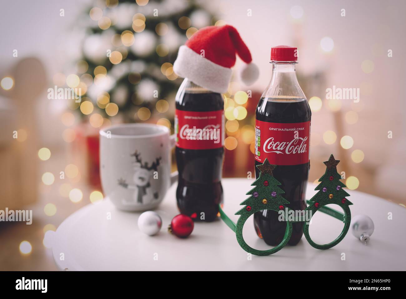 https://c8.alamy.com/comp/2N65HP0/mykolaiv-ukraine-january-01-2021-bottles-of-coca-cola-cup-and-party-glasses-on-table-against-blurred-christmas-lights-2N65HP0.jpg