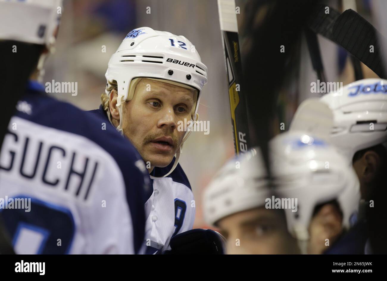 Winnipeg Jets center Olli Jokinen (12) of Finland checks New York Islanders  defenseman Thomas Hickey (14) in the first period of their NHL hockey game  at Nassau Coliseum in Uniondale, N.Y., Tuesday