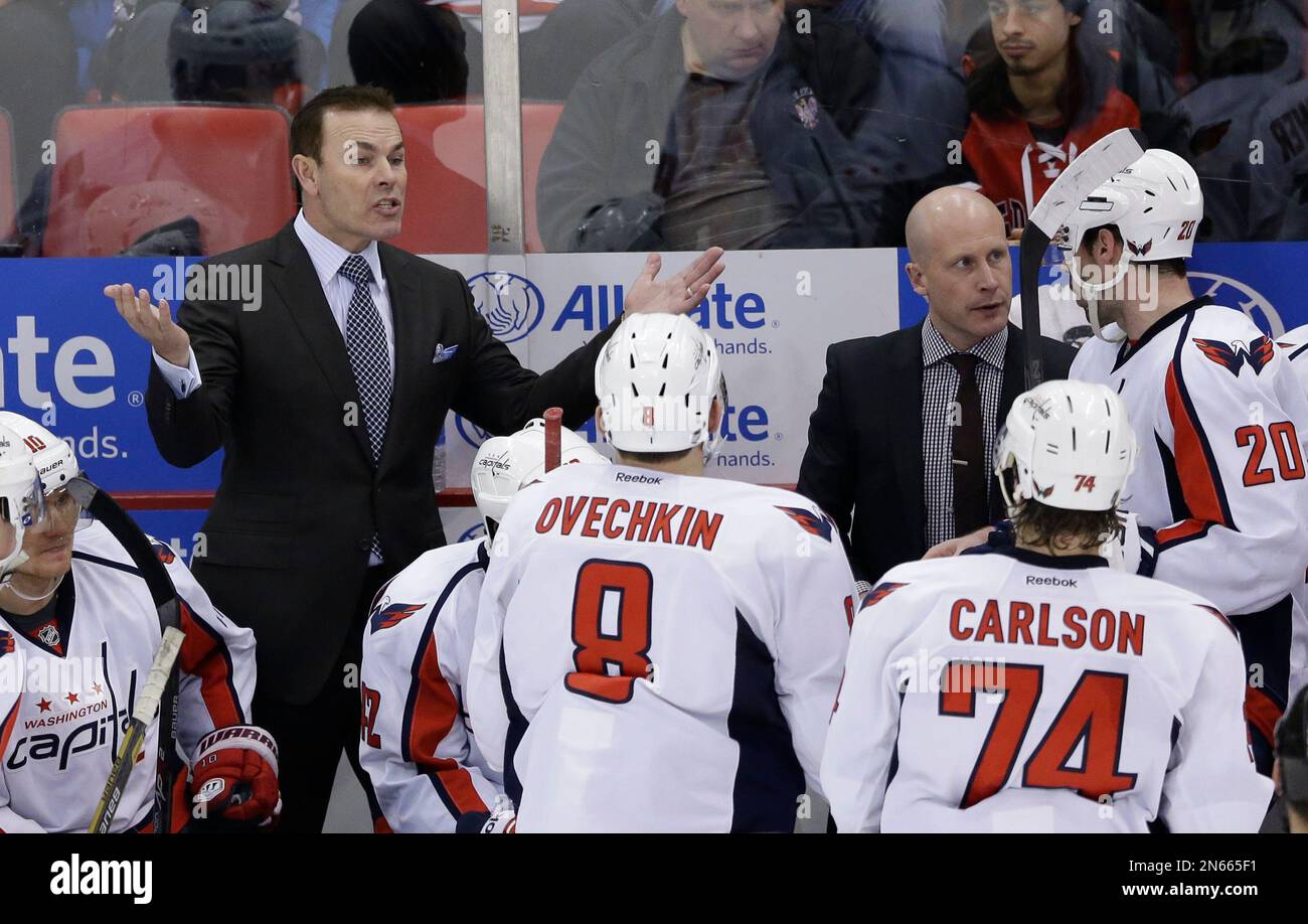 Washington Capitals coach Adam Oates, left, talks to his team during