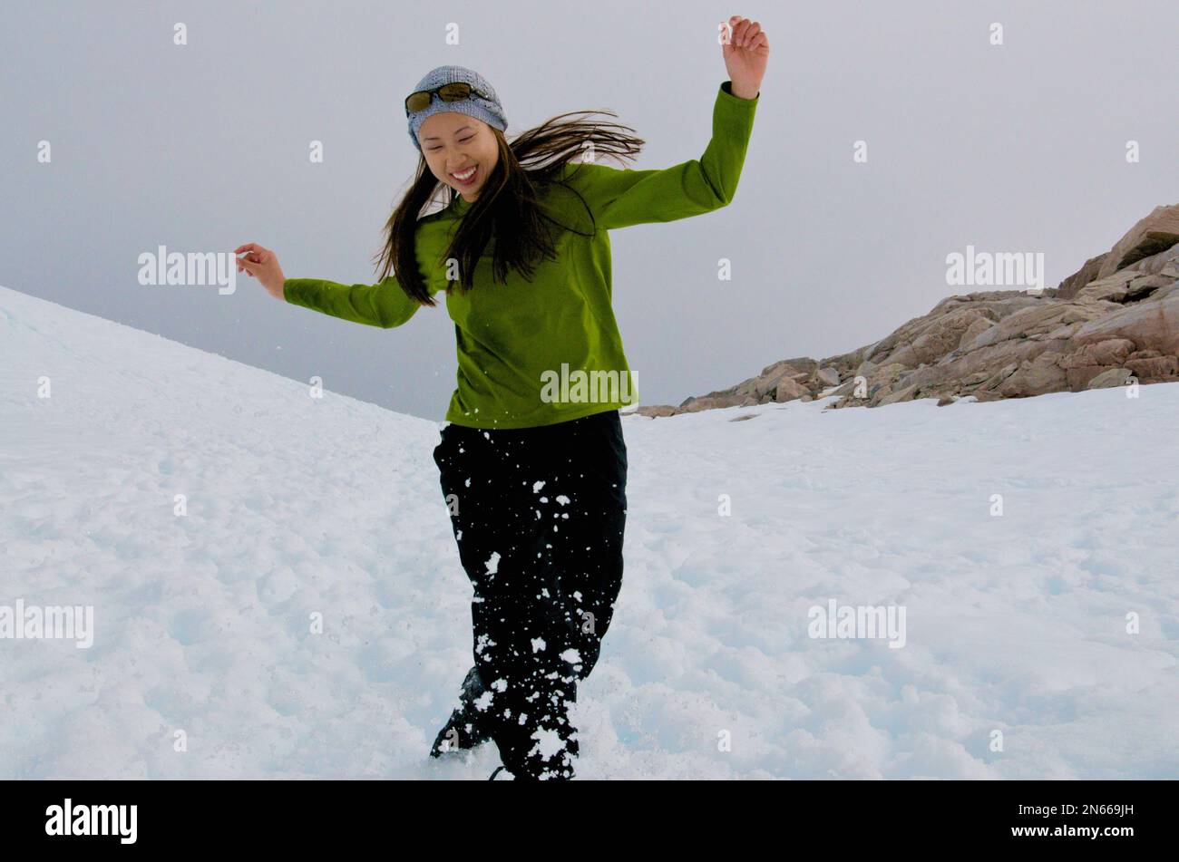 Asian woman playing in the snow, Antarctica Stock Photo