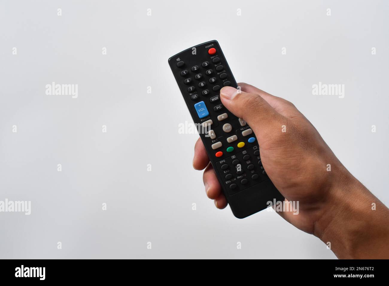 Hand holding television remote control isolated on white background Stock Photo