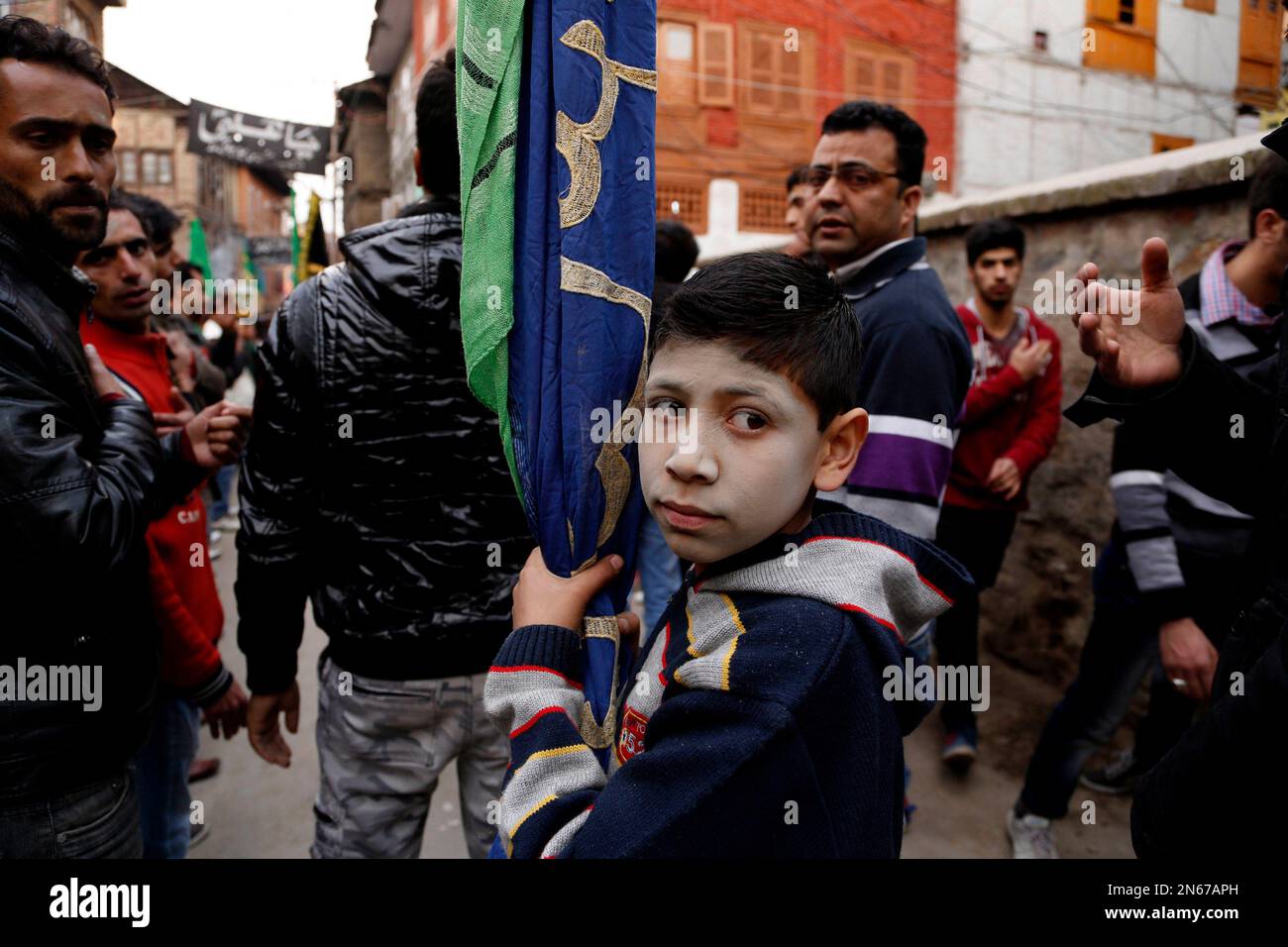 A Kashmiri Shiite Muslims boy holds a religious flag during a Muharram ...