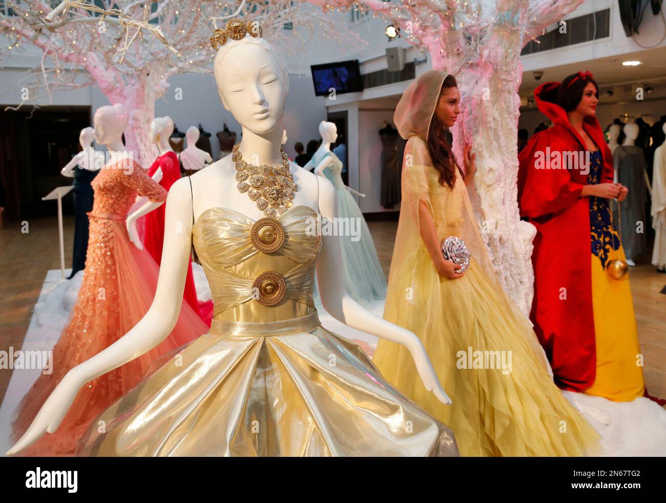 Models wear dresses depicting Disney characters Snow White and Belle, pose  for the photographers as other dresses depicting Disney characters are  exhibited ahead of an auction at Christie's auction house in London,