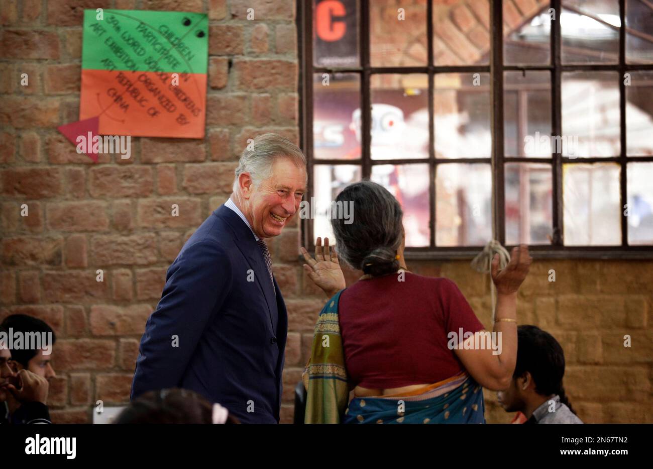 Britain's Prince Charles laughs as he speaks with a school official at Katha Lab School, a school for underprivileged children, in New Delhi, India, Friday, Nov. 8, 2013. Charles and his wife Camilla, the Duchess of Cornwall, are on a nine-day visit to India. (AP Photo/Saurabh Das) Stock Photo