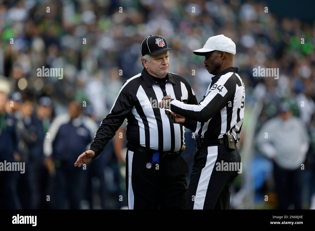 Field judge Mike Weir, left, talks with referee Mike Carey, right, in the first half of an NFL