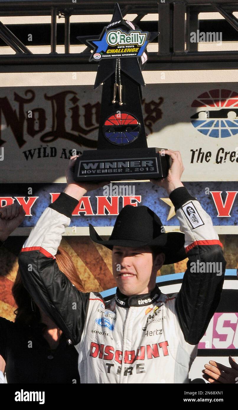 Brad Keselowski wears a cowboy hat and hoists the trophy after winning