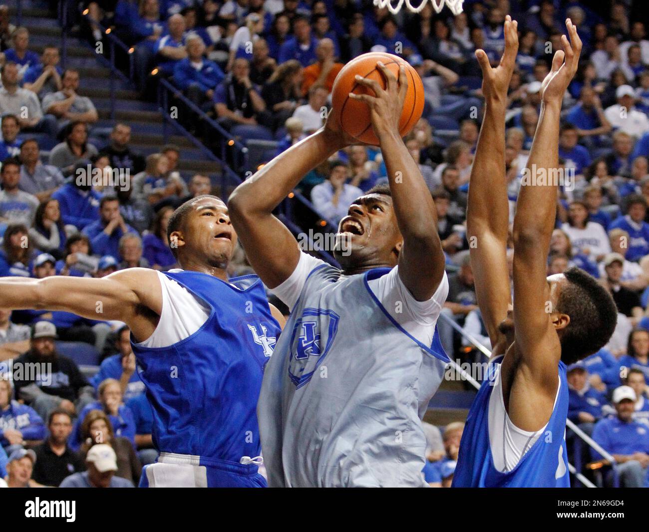 White team's Dakari Johnson, middle, shoots between Blue team's Aaron