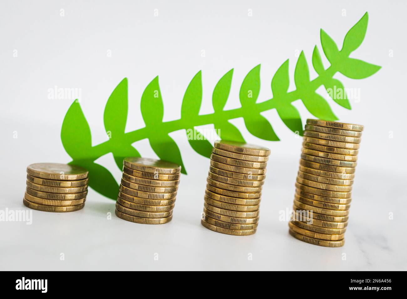 green economy investment and profit opportunities conceptual image, stacks of growing coins with green leaves  on them Stock Photo
