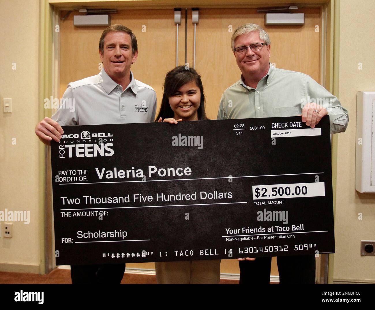 IMAGE DISTRIBUTED FOR BOYS AND GIRLS CLUB OF AMERICA - Taco Bell  franchisees, Mark Peterson, left, and Skip Chase, right, present Valeria  Ponce with a scholarship at the Boys & Girls Clubs