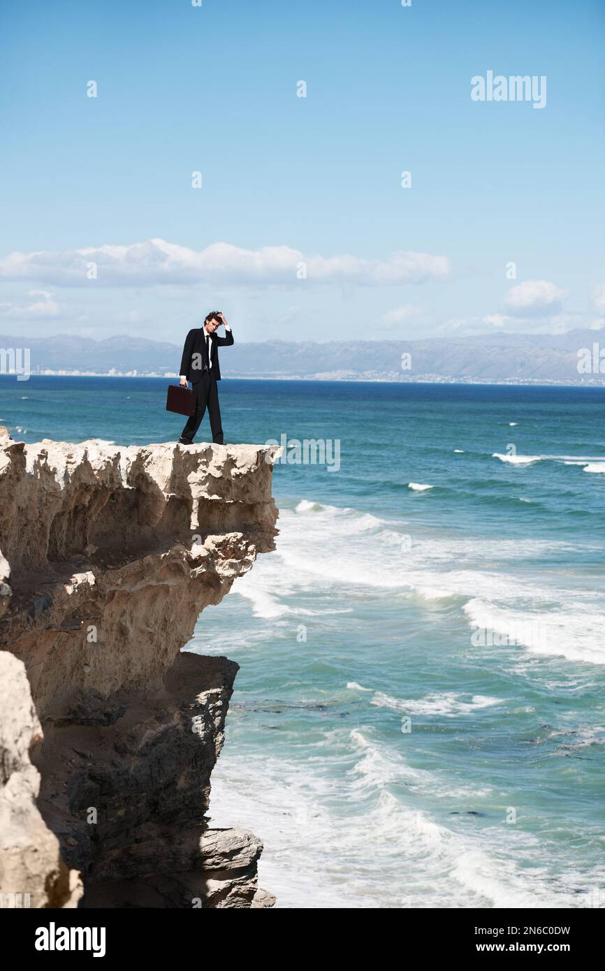 Where to go from here. Confused businessman standing on the edge of a ...