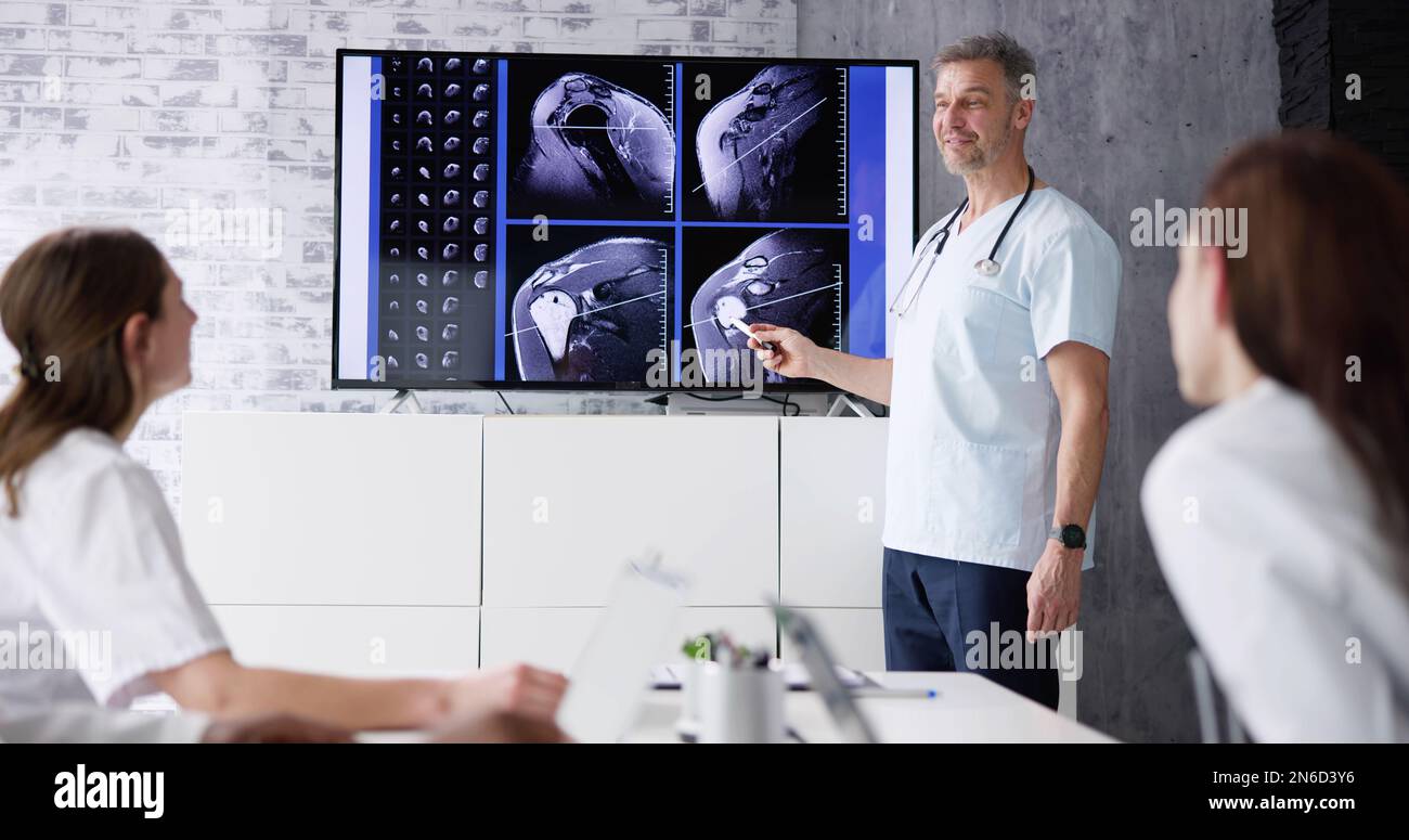 Physician Doctors Looking At Shoulder MRT Scan Stock Photo