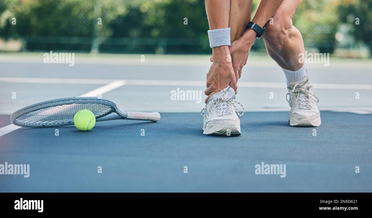 Tennis player with ankle pain on sports ground