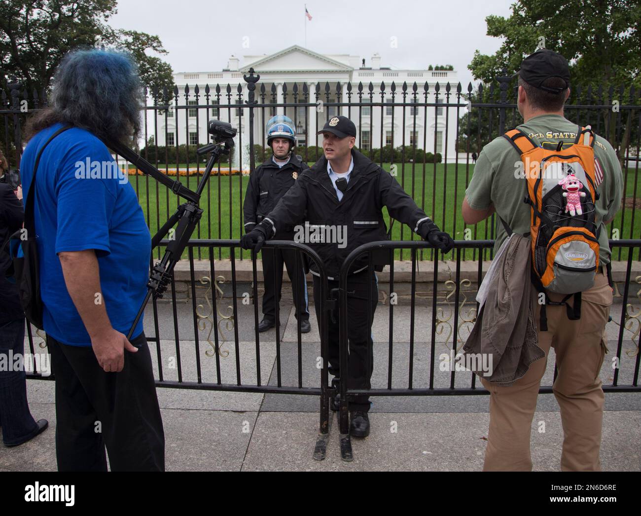 A member of the United States Park police swat team members stand guard at  the Statue of Liberty as visitors pose for photos, Thursday, July 4, 2013  at in New York. The