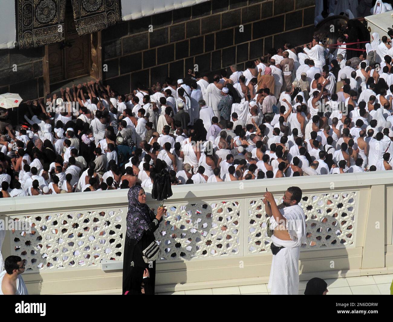 Muslim pilgrims take pictures in front of the Kaaba, the cube-shaped ...