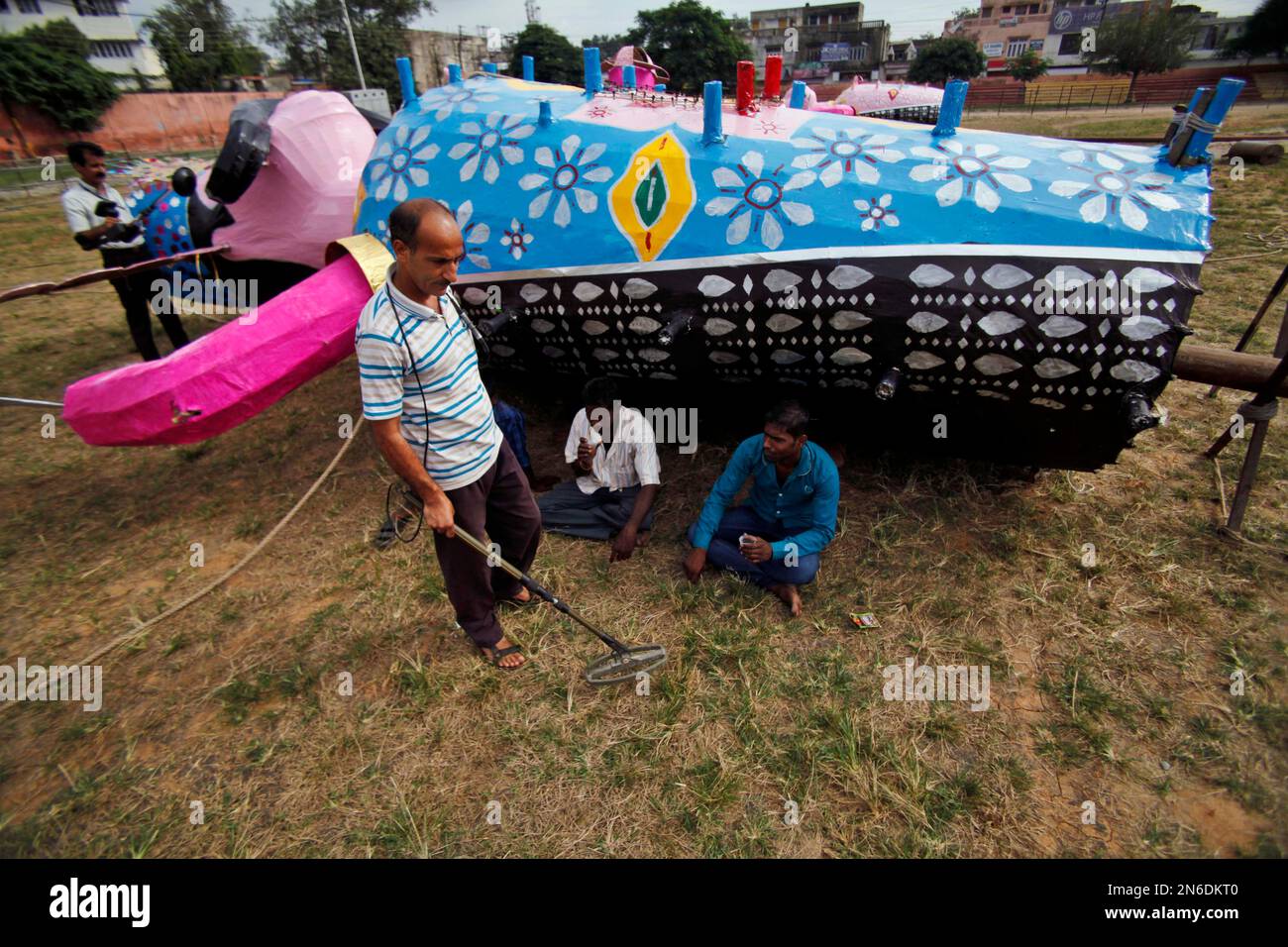 An Indian policeman, left, uses a metal detector to check the ground