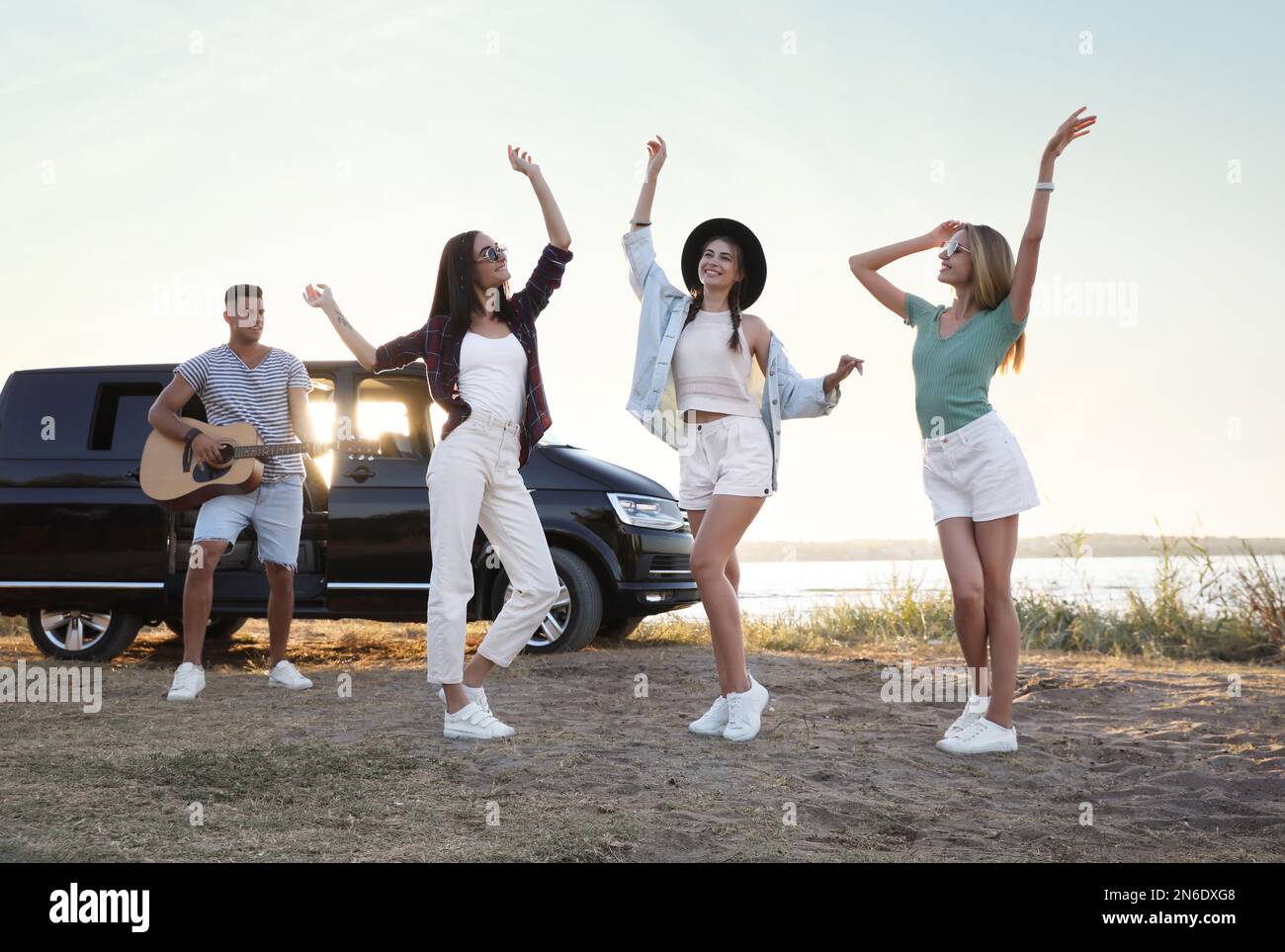 Happy friends having fun near car outdoors. Summer trip Stock Photo - Alamy
