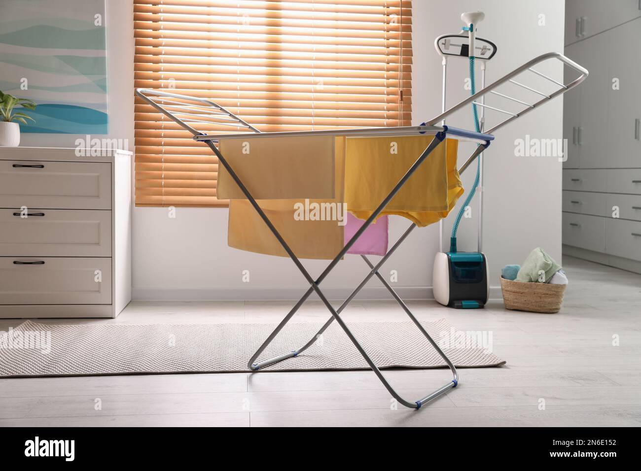 Clean laundry hanging on drying rack indoors Stock Photo Alamy