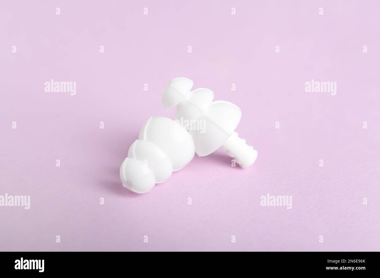 Pair of ear plugs on violet background Stock Photo