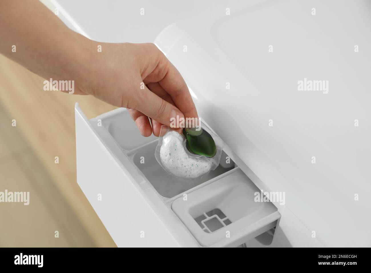 Woman putting laundry detergent capsule into washing machine, closeup Stock Photo Alamy