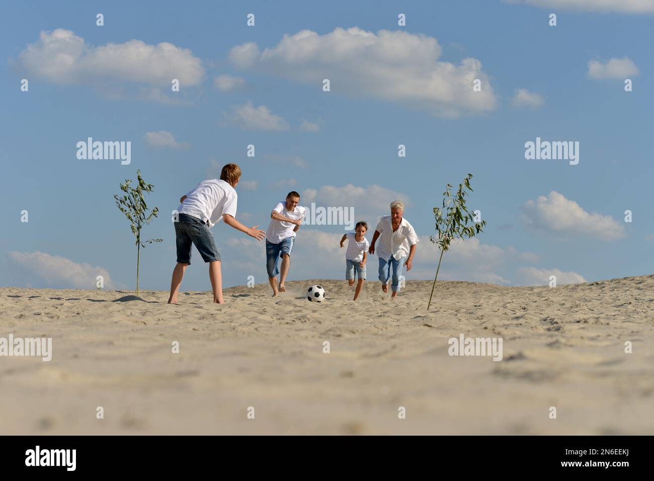 Family playing football on a beach in summer day Stock Photo - Alamy
