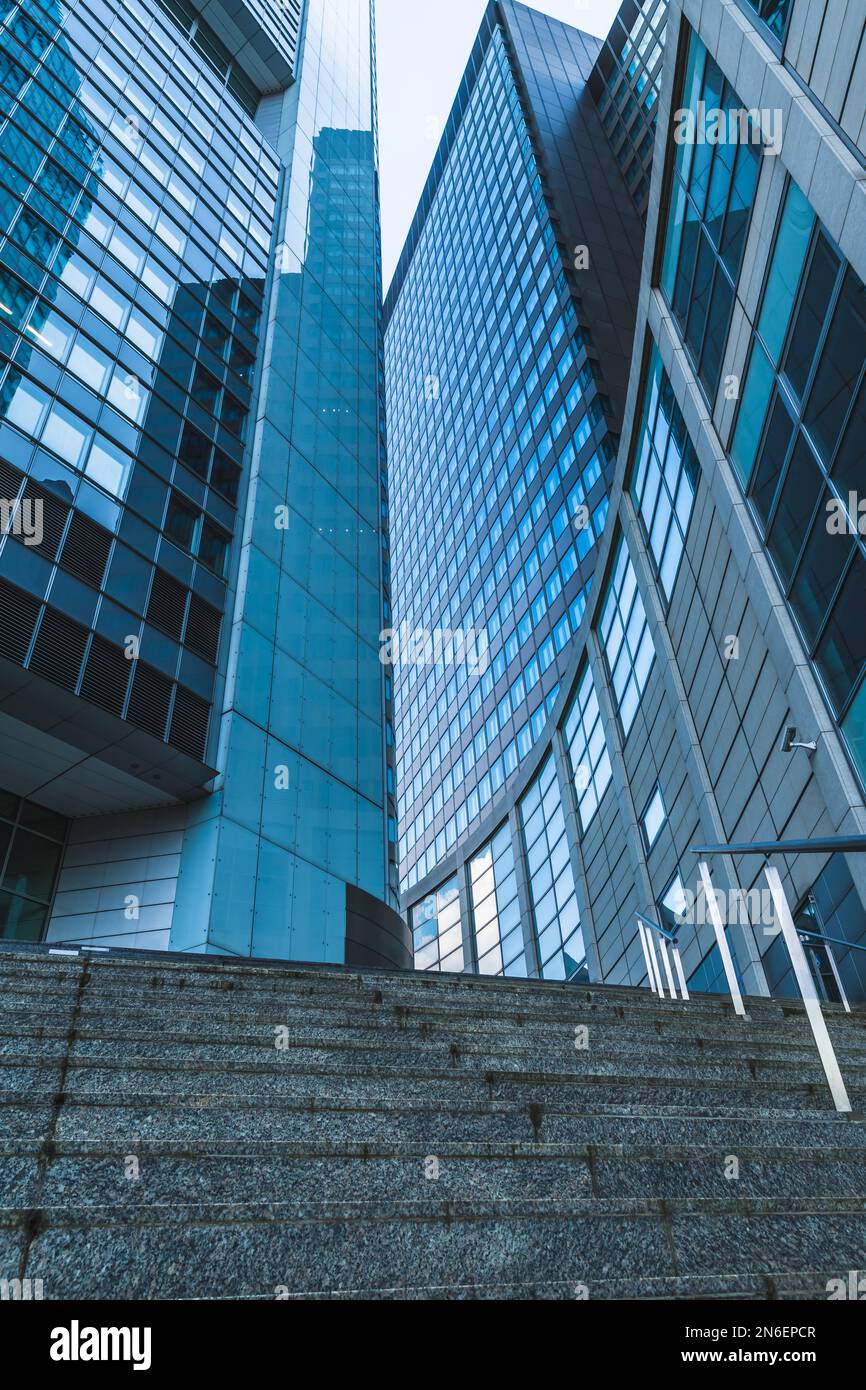 Modern building with glass facades reflecting parts of the building and wide staircase, vertical Stock Photo