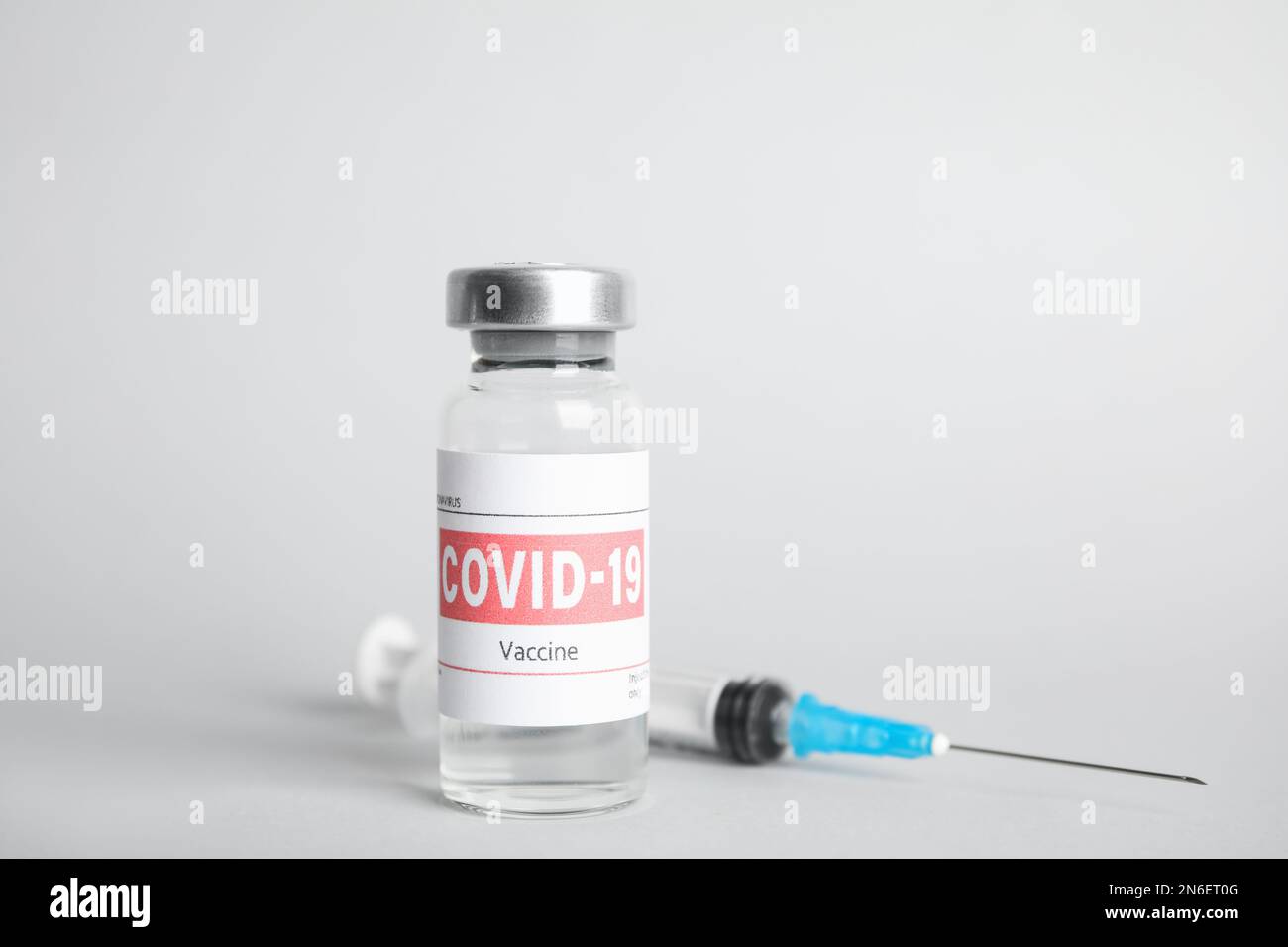 Vial with coronavirus vaccine and syringe on light background Stock ...