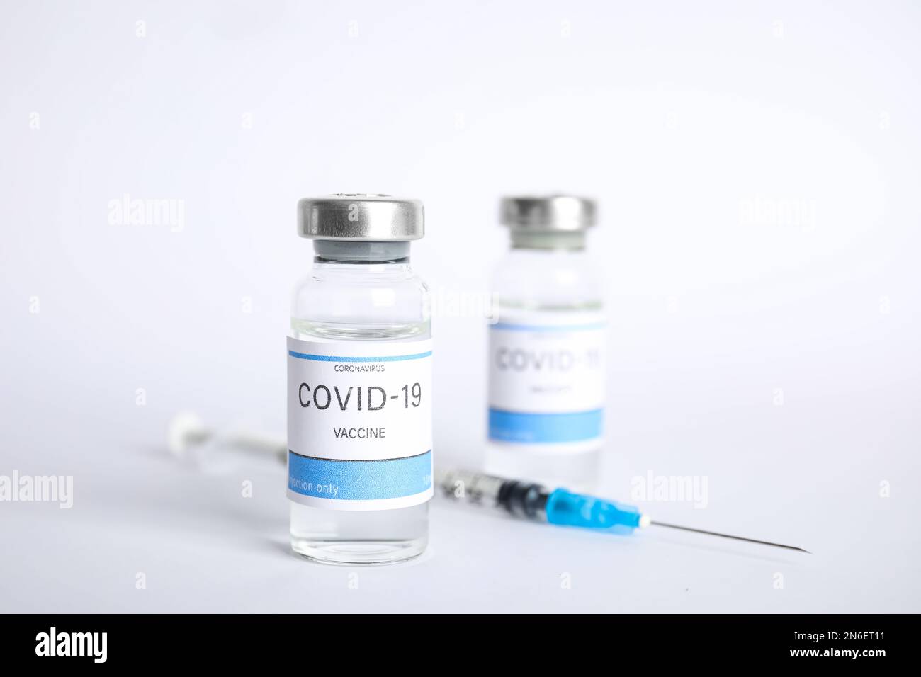 Vials with coronavirus vaccine and syringe on white background Stock ...